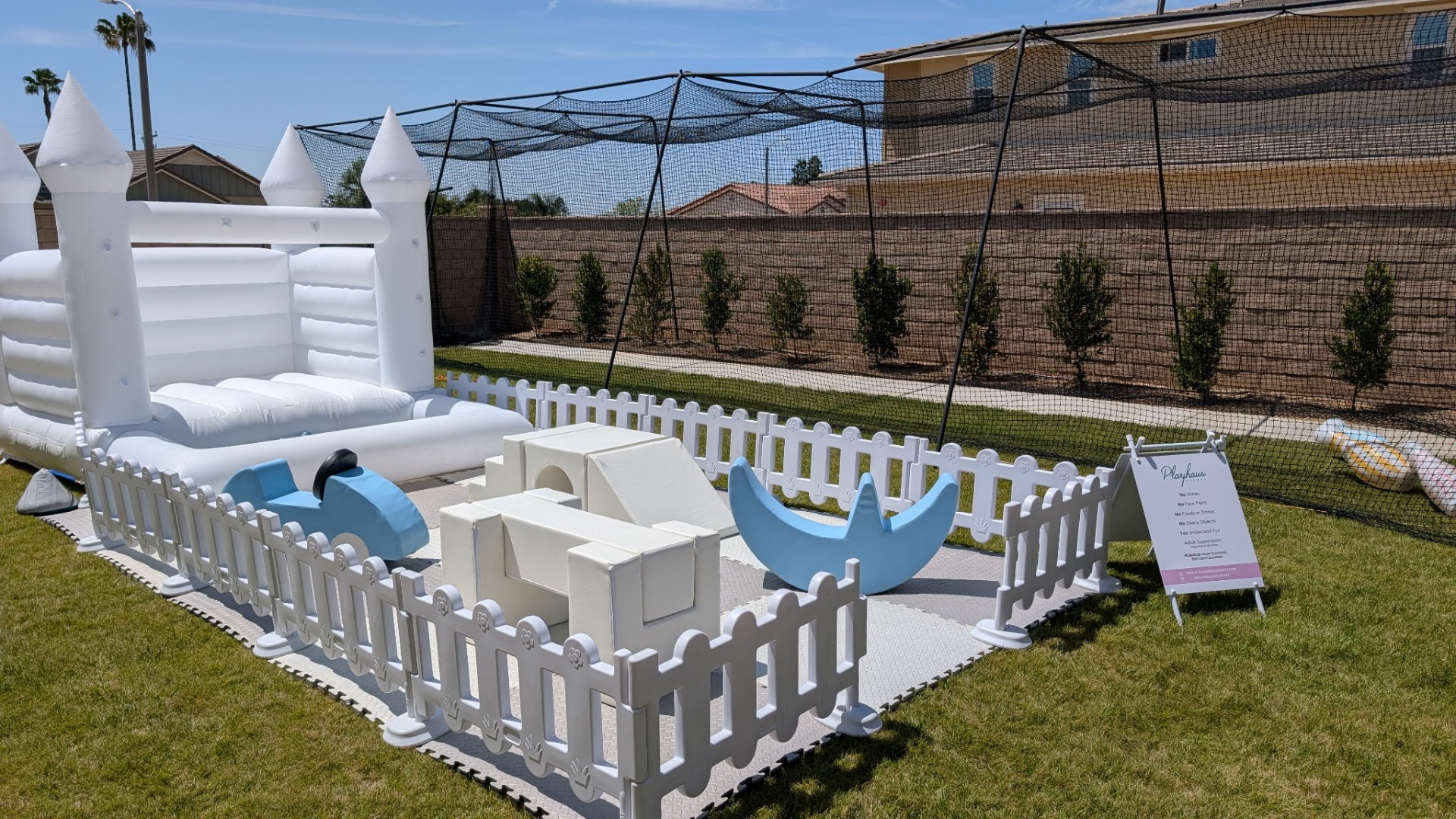 Castle bounce house with soft play in a backyard with measurements